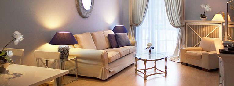 Übersicht des Wohnbereichs in der Suite mit Sofa, Sessel und Esstisch